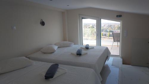 阿特米达AIR-IN Rooms with magnificent views的白色卧室设有两张床和大窗户