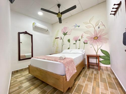 CurumaníHotel BJ Curumani的卧室配有一张墙上鲜花的床