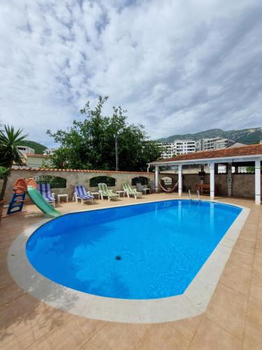 布德瓦Mila & Aleksandr Apartments的一个带椅子和滑梯的大型蓝色游泳池