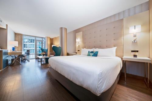 温哥华布鲁酒店的酒店客房设有一张大床和一张书桌。