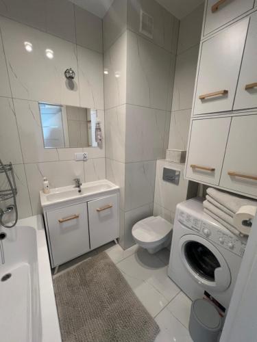 厄尔科Tani Nocleg Ełk - Apartament I love Ełk的浴室配有卫生间水槽和洗衣机。