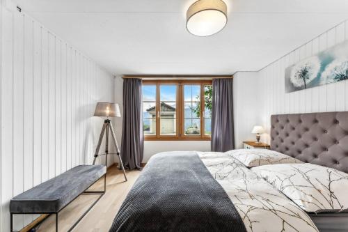 贝阿滕贝格App. Seeblick Top of Interlaken的一间卧室设有一张大床和一个窗户。