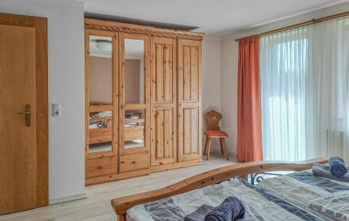 Regenhütte班豪斯K度假屋的一间卧室配有一张床和一个木制橱柜