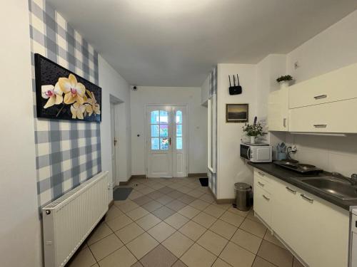 弗瓦迪斯瓦沃沃Margarita Pokoje i Apartamenty的厨房配有白色橱柜和水槽