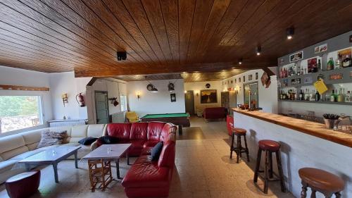 托尔德拉Rural Sant Llop的一间带红色沙发的客厅和一间酒吧