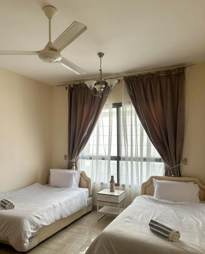 马斯喀特SIRA apartment 1的一间卧室设有两张床和窗户。