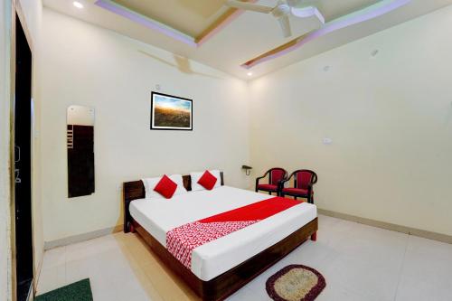 ChupraOYO Flagship Hotel Centre Point的一间卧室配有一张床和两张红色椅子