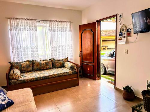 卡拉瓜塔图巴Praia Martin de Sá SP.的客厅的窗户前设有沙发