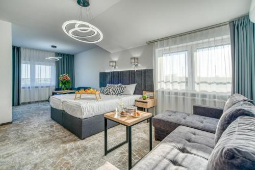 PoddębiceAcodomo Apartamenty的客厅配有床和沙发
