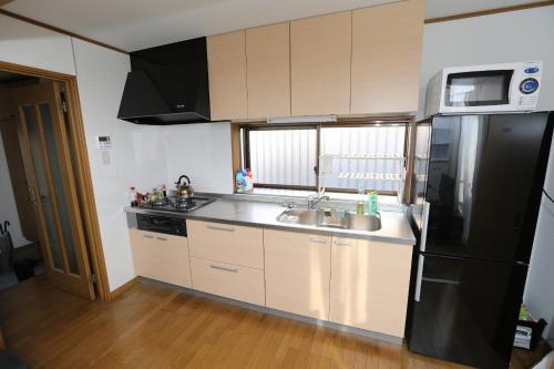东京J旅舍的厨房配有黑色冰箱和水槽