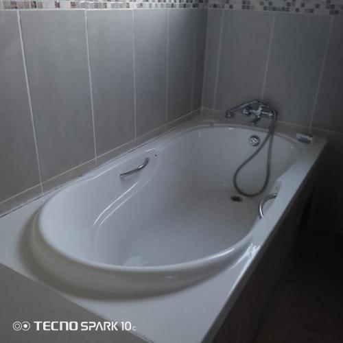 弗朗西斯敦Sunset Shades的浴室设有带淋浴的白色浴缸。