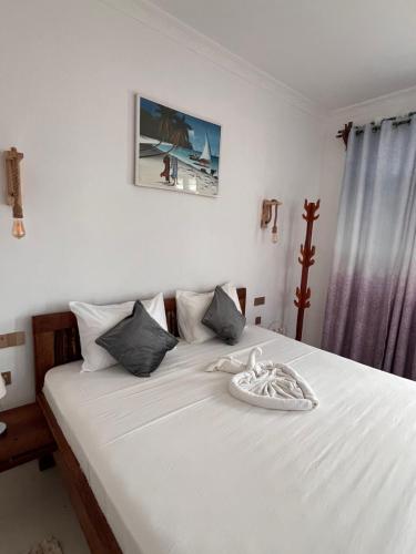 南威Nungwi Beach Front的一间卧室配有白色床单