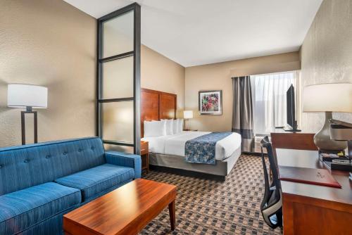 格林维尔Best Western Plus Greenville I-385 Inn & Suites的酒店客房,配有床和蓝色的沙发