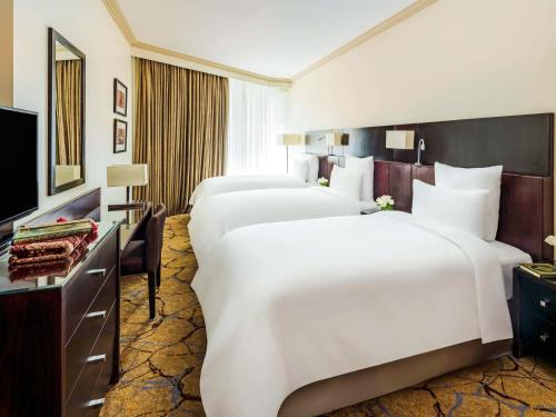 麦加麦加哈加塔瑞享酒店的酒店客房设有三张床和电视。