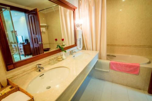 格卢市社楚罗西贡吉姆林度假酒店的浴室配有盥洗盆、镜子和浴缸