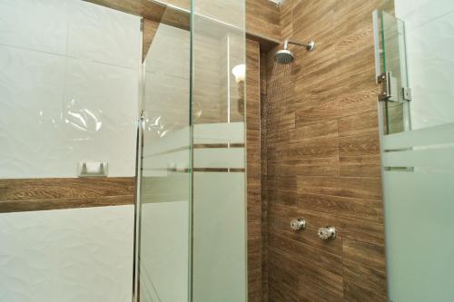 塔尔马Jeranco Hotel的浴室里设有玻璃门淋浴