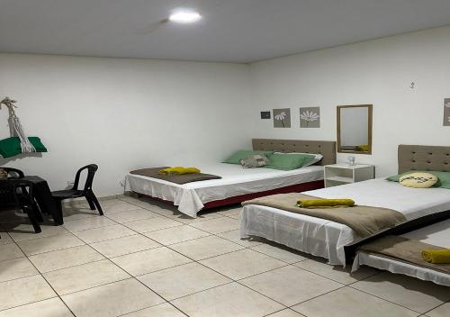 菲格雷多总统镇Residencial Margarida APART 5的一间设有两张床、椅子和镜子的房间