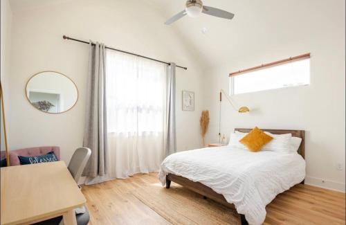 奥斯汀Contemporary NEW 10min dt Pet friendly 7min Park-A的一间卧室配有一张床、一张桌子和一个窗户。