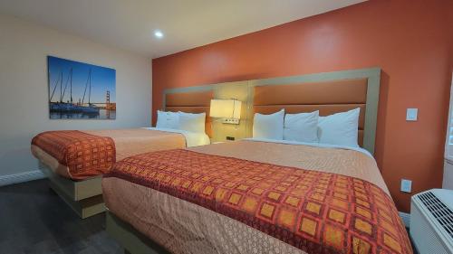 旧金山Presidio Parkway Inn的酒店客房,设有两张带橙色墙壁的床