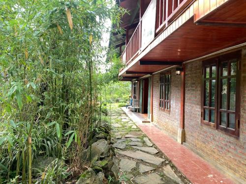 萨帕Sin Chai Eco Homestay的砖砌建筑,有走道,靠近一些树木