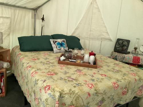 TurtletownSticks creekside Living的帐篷内的一张床位,上面有托盘