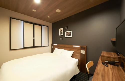 东京日本桥茅场町相铁Fresa Inn酒店的卧室配有白色的床和电视。