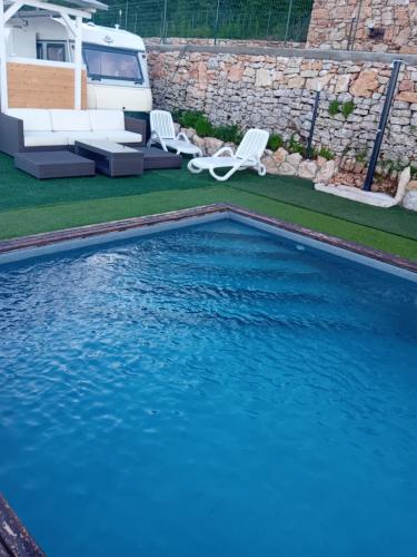 BiazaLE TERRAZZE SUL GARDA RELAIS的庭院内的游泳池,配有椅子和转轮