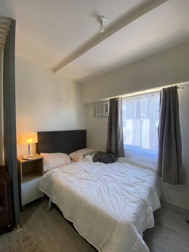 马尼拉Cozy & Minimalist Room at Amaia Steps Alabang的一间卧室设有一张大床和一个窗户。