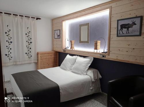 埃斯波特Casa Rural Felip的一间卧室配有一张床,窗户上装有鹿