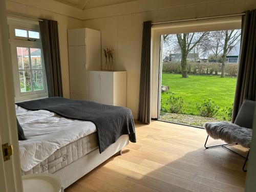 登乌弗Villa Nieuwland B&B的一间卧室设有一张床和一个大窗户