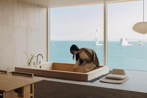 釜山Onyouji Stay的坐在浴室浴缸里的女人