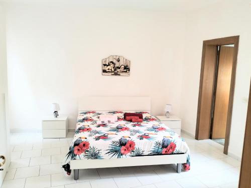 雷焦卡拉布里亚HOUSE MIRIAM的白色卧室配有一张带花卉床罩的床