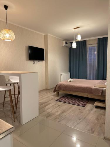 巴统Orange Batumi Travel的一间卧室配有一张床、一张桌子和一台电视。