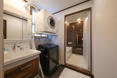 高山ROMANSTAY的一间带水槽、镜子和淋浴的浴室