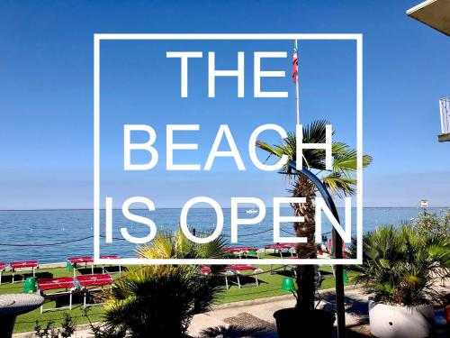 的里雅斯特马克西米利安里维埃拉酒店 的海滩上的一个大标志是开放的