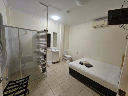 ClermontClermont Hotel Motel的一间卧室设有一张床、淋浴和卫生间