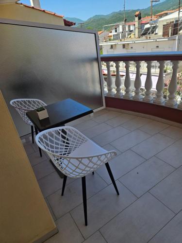 萨尔蒂petros house的阳台配有桌椅。