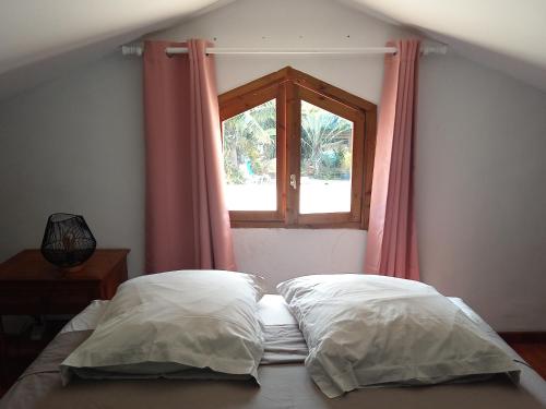 圣保罗Espace Détente des Calumets的卧室设有窗户和床上的2个枕头