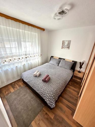 拉克塔希Apartman Lara Laktasi的一间卧室配有带两个枕头的床和窗户