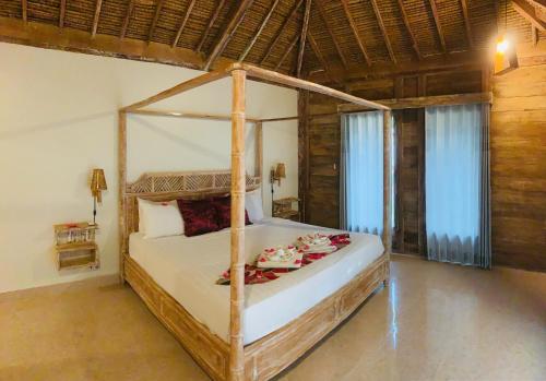 吉利特拉旺安Alwi Villa Gili Trawangan的一间卧室,卧室内配有一张天蓬床
