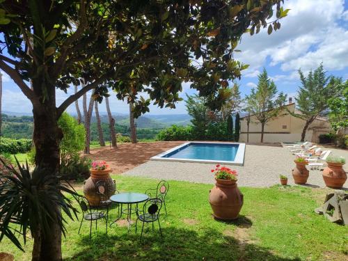 瓦尔的圣卡西亚诺伊佛迪诺别墅酒店的一个带桌椅的花园和一个游泳池