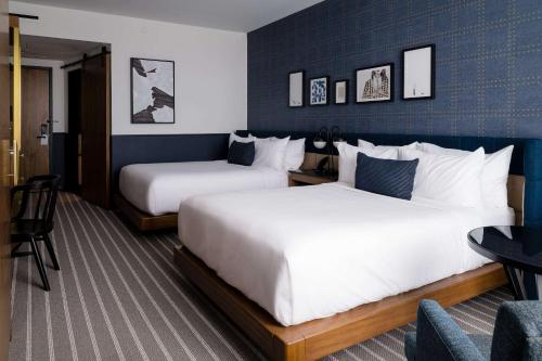 萨默维尔Cambria Hotel Boston Somerville的酒店客房,配有两张床和椅子
