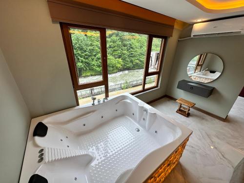 贾马里海姆森TUVA VİLLA Bungalov的带窗户的浴室内的白色大浴缸