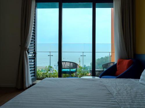 清化Khách sạn Flamigo Hải tiến的一间卧室设有一张床和一个大窗户