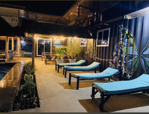 江比阿Jambiani Backpackers Hostel的一间设有蓝色长椅的餐厅,晚上设有庭院