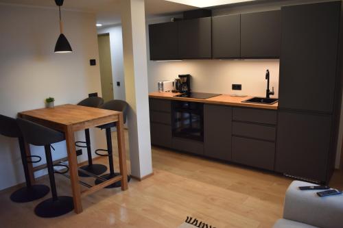 派尔努Suur-Posti Apartments的厨房配有木桌和柜台。