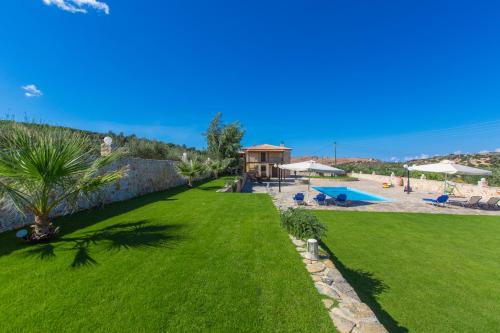 RoumelíNestor Villa, with Private Pool & Absolute Privacy的绿色草坪,设有游泳池和度假村