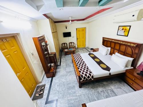 伊斯兰堡Lexus Lodge的一间卧室配有一张床,并在一间客房内配有电视。