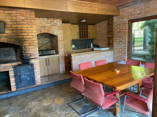 普里兹伦The Hill House的厨房配有木桌和砖砌壁炉。