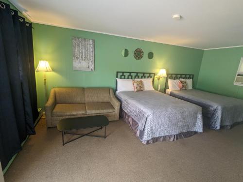 Barrys BayPinewood Inn的一间卧室配有两张床、一张沙发和一把椅子